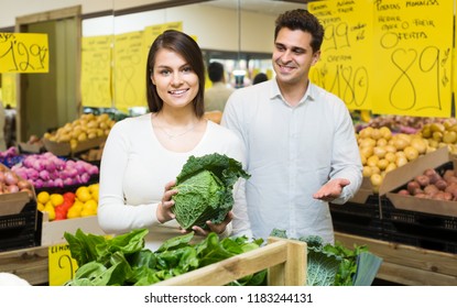 Happy Young Family Choosing Veggies In Grocery Store