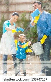 Happy Young Family Cleaning Home Window Glass