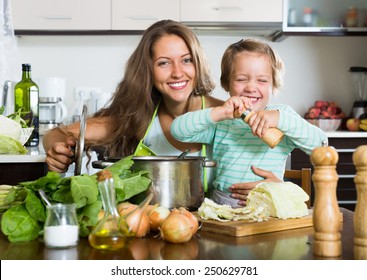 Happy Young  Family Cooking Soup  At Home Kitchen