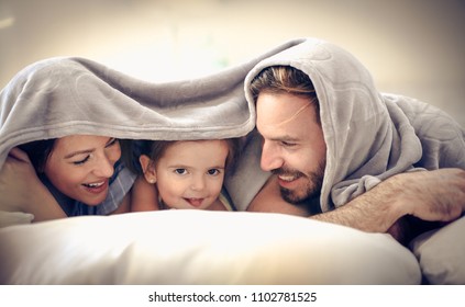 Happy Young Family Covered Over Head. Space For Copy.