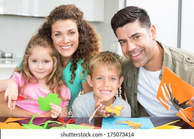 Happy Young Family Doing Arts And Crafts At The Table At Home In Kitchen