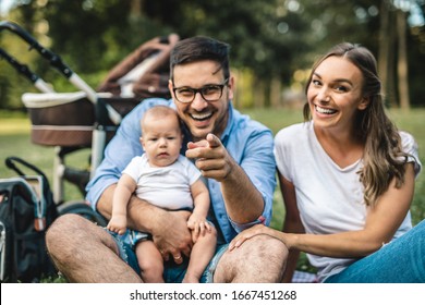 Happy Young Family Enjoying Together In Park.