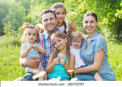 Happy Young Family With Four Children In The Spring Forest