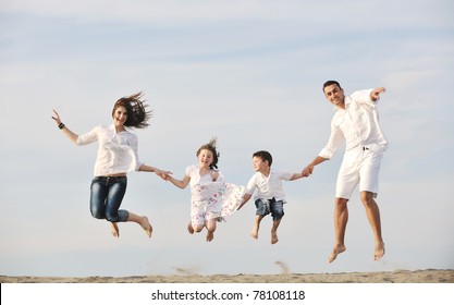 Happy Young Family Have Fun And Live Healthy Lifestyle On Beach