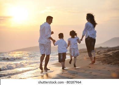 Happy Young Family Have Fun And Live Healthy Lifestyle On Beach