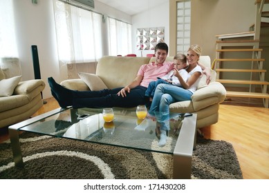 Happy Young Family With Kids In Bright Modern Living Room Have Fun And Looking Big Flat Lcd Tv