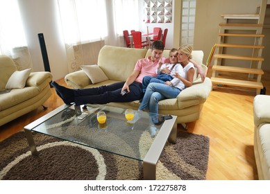 Happy Young Family With Kids In Bright Modern Living Room Have Fun And Looking Big Flat Lcd Tv