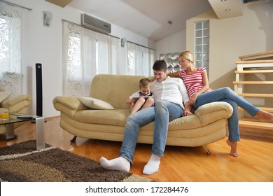 Happy Young Family With Kids In Bright Modern Living Room Have Fun