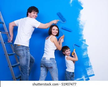 Happy Young Family With Little Son Painting The Wall