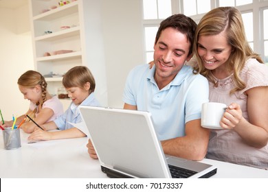 Happy Young Family Looking And Reading A Laptop Computer