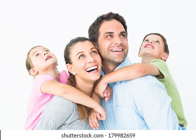 Happy Young Family Looking Up Together On White Background