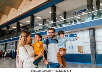 Happy young family with luggage in railroad station go together on vacation. - Shutterstock ID 2162989473