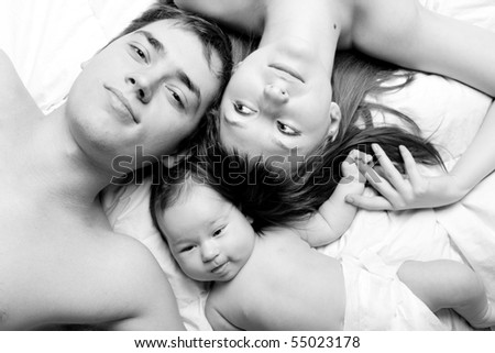 Similar – Mother reading book to her sons in the bed