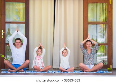 Happy young family meditating on the terrace - Powered by Shutterstock