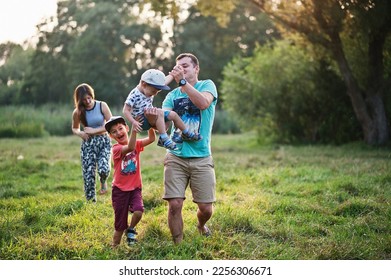 Happy young family: mother, father, two children son on nature having fun. - Shutterstock ID 2256306671