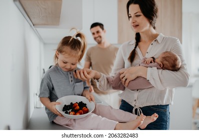 Happy Young Family With Newborn Baby And Little Girl Enjoying Time Together At Home, Daily Routine Concept.