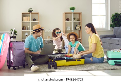 Happy young family packing bags for vacation trip. Parents and kids getting ready for cruise holiday and putting all necessary things and beach clothes to wear in modern travel suitcases together - Powered by Shutterstock