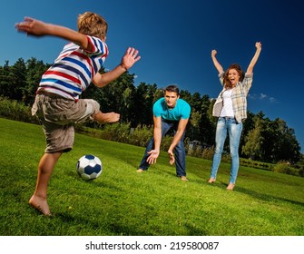 Happy Young Family Playing Football Outdoors 