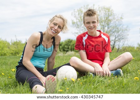 A happy young family playing football outdoor on a summer day