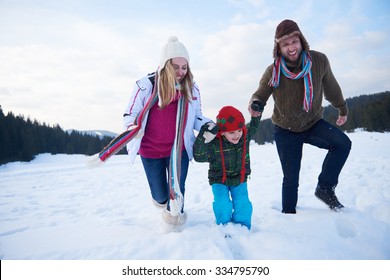 Happy Young  Family Playing In Fresh Snow  At Beautiful Sunny Winter Day Outdoor In Nature