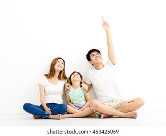 Happy  Young  Family Pointing And Looking Up