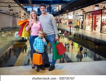 Happy  Young Family With Shopping Bags In Mall