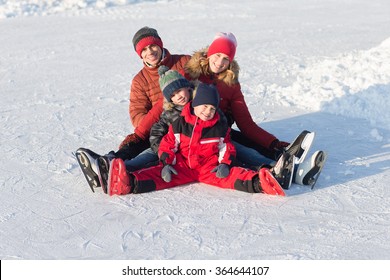 Happy Young Family Skate At The Rink In The Winter. Beautiful Family Walking And Playing On The Ice In Winter.