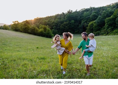 Happy young family spending time together outside in green nature. - Powered by Shutterstock