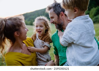 Happy Young Family Spending Time Together Outside In Green Nature.