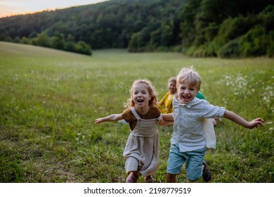 Happy Young Family Spending Time Together Outside In Green Nature.