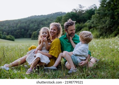 Happy Young Family Spending Time Together Outside In Green Nature.