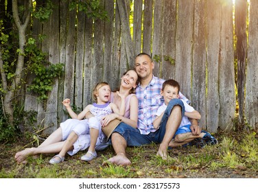 Happy Young Family Spending Time Together Outside In Nature.