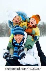 Happy Young Family Spending Time Outdoor In Winter