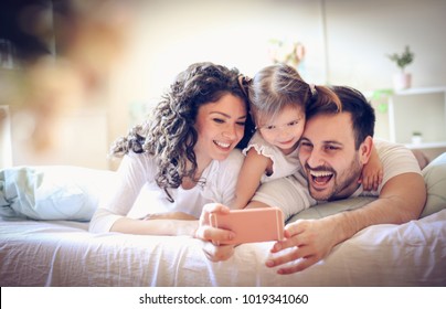Happy young family take a self portrait with smart phone.  - Shutterstock ID 1019341060