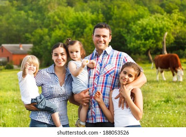 Happy Young Family With Three Children On The Farm