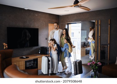 Happy young family with two children enetring room at luxury hotel, summer holiday. - Powered by Shutterstock