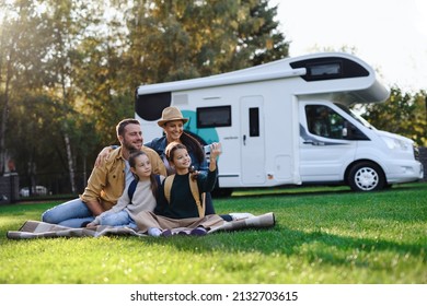 Happy young family with two children ltaking selfie with caravan at background outdoors. - Powered by Shutterstock