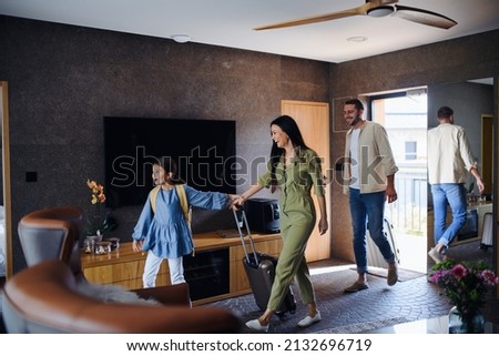 Happy young family with two children enetring room at luxury hotel, summer holiday.