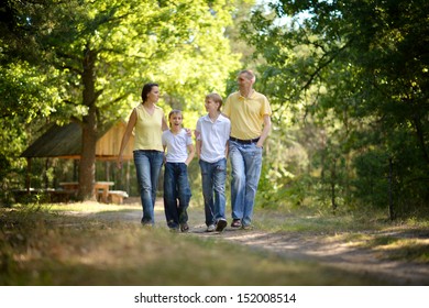 Happy Young Family Walking In A Park