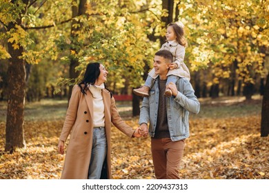 Happy Young Family Walks In The Autumn Park