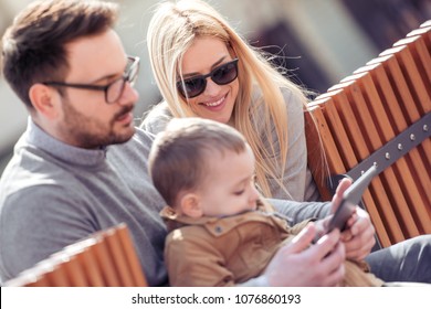 Happy young family watching cartoon on tablet. - Shutterstock ID 1076860193