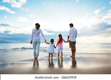 Happy Young Family Watching The Sunset At The Beach.  Happy Family Lifestyle 