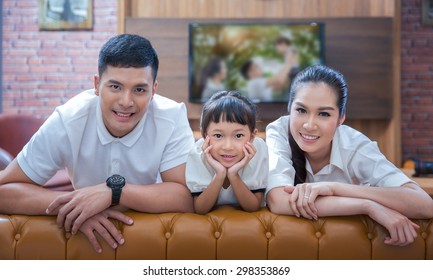 Happy Young Family Wathching Flat Tv At Vintage Home Indoor