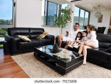 Happy Young Family Wathching Flat Tv At Modern Home Indoor