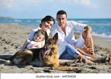 Happy Young Family In White Clothing Have Fun And Play With Beautiful Dog At Vacations On Beautiful Beach