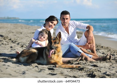 Happy Young Family In White Clothing Have Fun And Play With Beautiful Dog At Vacations On Beautiful Beach