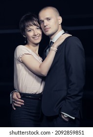 Happy Young Fashion Couple Walking On City Street At Night Stylish Man In Black Business Suit And Woman In Light Pink Blouse And Skirt