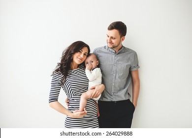 Fröhlicher junger Vater, Mutter und süßer Kleinkind auf weißem Hintergrund