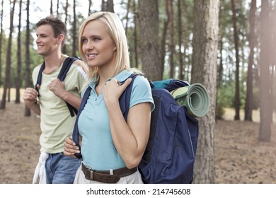 Happy Young Female Backpacker With Man Hiking In Woods