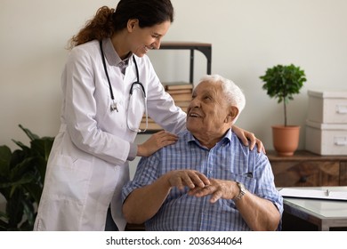 Happy young female GP doctor giving hug and support to optimistic old 80s patient. Senior man visiting, consulting therapist, discussing successful treatment, recovery, remission, good health - Shutterstock ID 2036344064